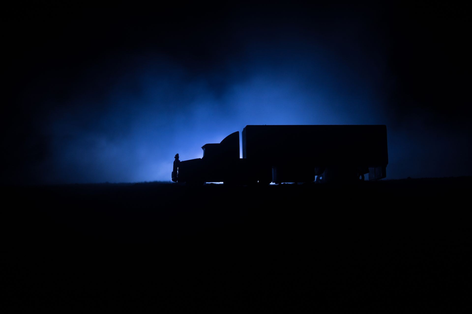 Big truck wagon rides on the road outside the city at night with foggy background. Decoration. Selective focus